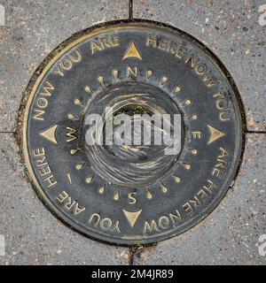 Phoenix, Arizona - 11. November 2022: Dieses Kunstwerk im „Manhole-Stil“ an einer Stadtbahnstation in der Innenstadt hat die vier Kardinalpunkte eines Kompasses, eines zentralen Imag Stockfoto