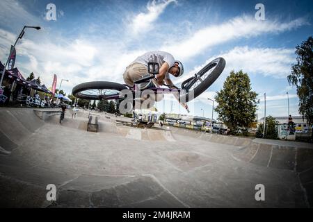 Ein junger Mann, der während des BMX-Rennens im Skate Park in Kosice auf ein Fahrrad springt Stockfoto