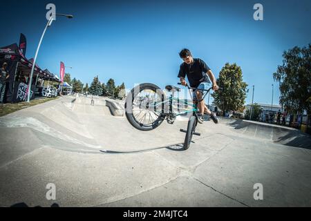 Ein junger Mann, der während des BMX-Rennens im Skate Park in Kosice auf ein Fahrrad springt Stockfoto