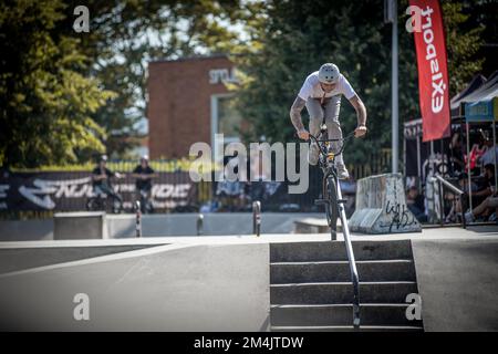 Ein junger Mann, der während des BMX-Rennens im Skate Park in Kosice auf ein Fahrrad springt Stockfoto