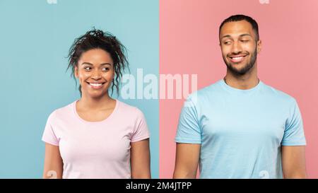 Porträt eines positiven afroamerikanischen Ehepaars, das über einem halbrosa-blauen Studiohintergrund steht und sich gegenseitig anschaut Stockfoto