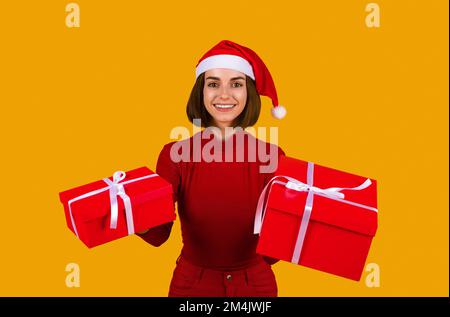 Süße, hübsche junge Frau, Weihnachtsgeschenke in der Hand Stockfoto