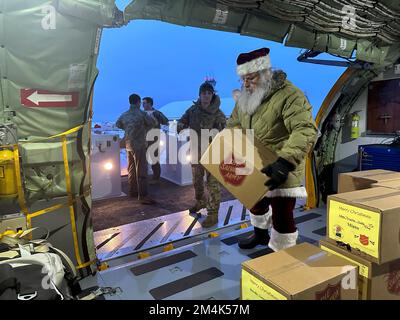 Nordpol, Vereinigte Staaten von Amerika. 22. November 2022. Der Weihnachtsmann und seine Elfen entladen während der Operation Santa Claus am Luftwaffenstützpunkt Eielson am 22. November 2022 in Nordpol, Alaska, Kisten aus einem 168.-Flügel KC-135 Stratotanker-Flugzeug. Der Weihnachtsmann und die Heilsarmee liefern mit Hilfe der Nationalgarde und der Heilsarmee Weihnachtsgeschenke, Bücher, Schulbedarf und Leckereien für Jugendliche in abgelegenen ländlichen Gemeinden in Alaska. Kredit: Dana Rosso/National Guard/Alamy Live News Stockfoto