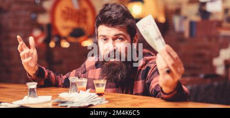 Hipster hat Geld, Geld, um mehr Alkohol zu kaufen. Stockfoto