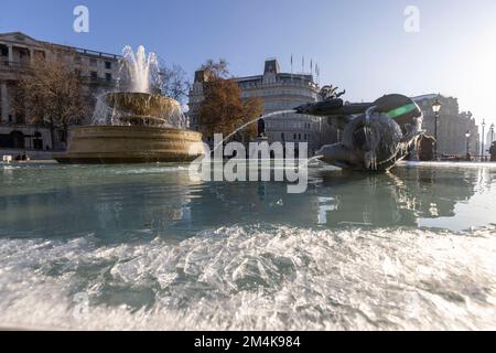Der Brunnen am Trafalgar Square bleibt bis zum Morgen gefroren. Die Leute haben Spaß mit Eisstücken auf dem Brunnen. Aufnahme am 16. Dezember 2022. ©B Stockfoto