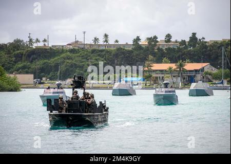 SANTA RITA, Guam (15. Dezember 2022) Spezialeinsatzkräfte in einem Spezialeinsatzfahrzeug am Flussufer, an der Front und zwei Kampfboote greifen an, Mitte, und zwei Kampfboote MittelTransit Apra Harbor, um Taktiken zu verfeinern, die Naval Special Warfare in Flottenoperationen integrieren. Naval Special Warfare ist die landesweit führende Spezialeinsatztruppe für die Seeschifffahrt und ist in einer einzigartigen Position, um die Reichweite der Flotte zu erweitern und allen Bereichen Optionen für Marinekommandeure und gemeinsame Einsatzkräfte anzubieten. Stockfoto