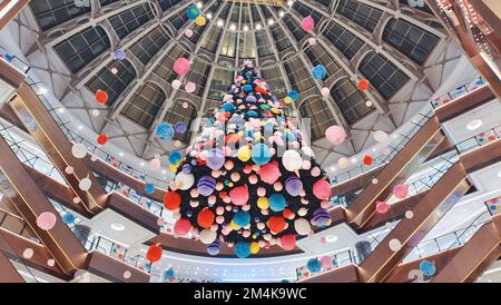 SHANGHAI, CHINA - 21. DEZEMBER 2022 - Ein riesiger „schwimmender Weihnachtsbaum“ wird auf dem Ganghui Heng Lung Plaza ausgestellt, einem Wahrzeichen-Einkaufszentrum von Xujiahui, Stockfoto