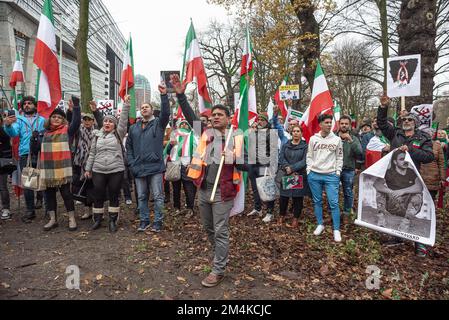 Den Haag, Niederlande, 21/12/2022, Eine Gruppe männlicher und weiblicher Demonstranten, während der heutigen Demonstration in Den Haag, bei der das iranische Regime angeprangert wird; mit Flaggen und Plakaten. Eine nicht allzu große, aber sehr lautstarke Gruppe iranischer Anhänger hat heute Nachmittag einen lauten Protest inszeniert und das niederländische Repräsentantenhaus aufgefordert, die iranische Botschaft in den Niederlanden zu schließen und ihre Diplomaten auszuweisen. Vor einigen Wochen brachen im Iran Massendemonstrationen aus, nachdem die Sicherheitskräfte hart gegen Demonstranten vorgegangen waren. Von den vorgenommenen Verhaftungen waren zwei für den plötzlichen Tod des 22-jährigen Mahsa Amin und des 17-jährigen Ols verantwortlich Stockfoto