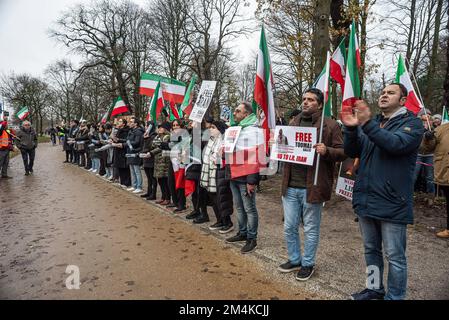 Den Haag, Niederlande, 21/12/2022, Eine Gruppe männlicher und weiblicher Demonstranten, während der heutigen Demonstration in Den Haag, in der das iranische Regime angeprangert wird; mit Flaggen und Plakaten. Eine nicht allzu große, aber sehr lautstarke Gruppe iranischer Anhänger hat heute Nachmittag einen lauten Protest inszeniert und das niederländische Repräsentantenhaus aufgefordert, die iranische Botschaft in den Niederlanden zu schließen und ihre Diplomaten auszuweisen. Vor einigen Wochen brachen im Iran Massendemonstrationen aus, nachdem die Sicherheitskräfte hart gegen Demonstranten vorgegangen waren. Von den Verhaftungen waren zwei für den plötzlichen Tod des 22-jährigen Mahsa Amin und des 17-jährigen verantwortlich Stockfoto