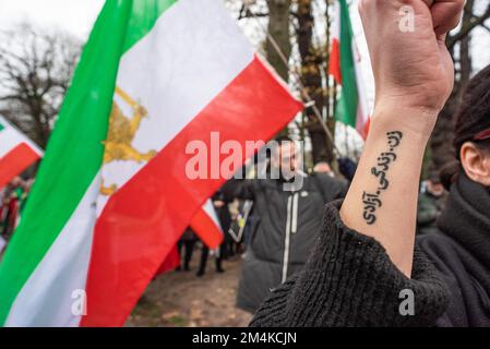 Den Haag, Niederlande, 21/12/2022, weibliche Demonstrantin während der heutigen Demonstration in Den Haag, die das iranische Regime mit einer Tätowierung verurteilt, auf der steht: "Frau, Freiheit des Lebens". Eine nicht allzu große, aber sehr lautstarke Gruppe iranischer Anhänger hat heute Nachmittag einen lauten Protest inszeniert und das niederländische Repräsentantenhaus aufgefordert, die iranische Botschaft in den Niederlanden zu schließen und ihre Diplomaten auszuweisen. Vor einigen Wochen brachen im Iran Massendemonstrationen aus, nachdem die Sicherheitskräfte hart gegen Demonstranten vorgegangen waren. Von den vorgenommenen Verhaftungen waren zwei für den plötzlichen Tod des 22-jährigen Mahsa Amin und des 17-jährigen verantwortlich Stockfoto