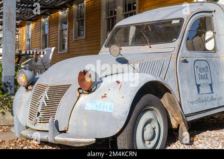 NEW ORLEANS, LA, USA - 18. DEZEMBER 2022: Front of Beat Up 1950er Modell Citroen 2CV mit französischem Truck Coffee Logo auf der Fahrertür Stockfoto