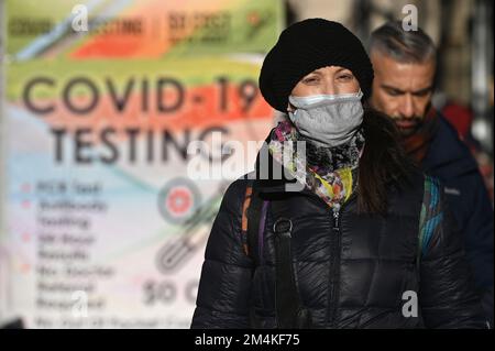 New York, USA. 21. Dezember 2022. Eine Frau trägt zwei Masken, während sie am Broadway in Lower Manhattan, New York, New York, am 21. Dezember 2022 spaziert. Inmitten der dreifachen Bedrohung von Covid-19, Grippe und RSV, auch Tripledemie genannt“, ermutigt die CDC, wieder Masken zu tragen, Monate nachdem die Mandate der Maske beendet sind. (Foto: Anthony Behar/Sipa USA) Guthaben: SIPA USA/Alamy Live News Stockfoto