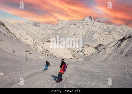 Tolle Aussicht auf Freerider auf Snowboards, die von der Spitze des Kammes vor dem Kazbek Mountain hinunterfahren. Gudauri, Kaukasus, Georgien Stockfoto