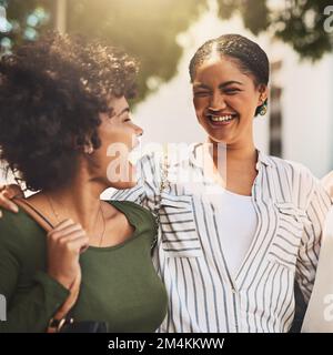 Wir sind zusammen aufgewachsen. Zwei fröhliche junge Freunde standen zusammen und lachten tagsüber den ganzen Weg draußen. Stockfoto