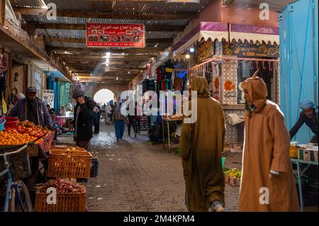 Rissani, Provinz Errachidia, Marokko - 24. November 2022: Verkäufer und Käufer auf einem typischen arabischen Straßenmarkt. Stockfoto