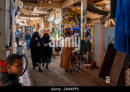 Rissani, Provinz Errachidia, Marokko - 24. November 2022: Verkäufer und Käufer auf einem typischen arabischen Straßenmarkt. Stockfoto