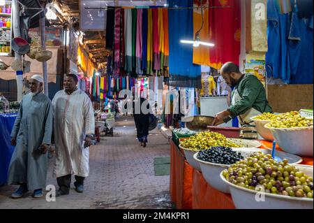 Rissani, Provinz Errachidia, Marokko - 24. November 2022: Verkäufer und Käufer auf einem typischen arabischen Straßenmarkt. Stockfoto