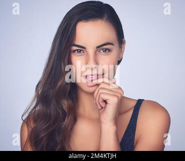 Sie liebt strahlende und makellose Haut. Studioaufnahme einer wunderschönen jungen Frau, die vor einem lila Hintergrund posiert. Stockfoto