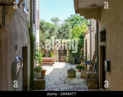 Ein wunderschönes Bild von alten Gebäuden in einer engen Straße in Porec, Istrien, Kroatien an einem sonnigen Tag Stockfoto