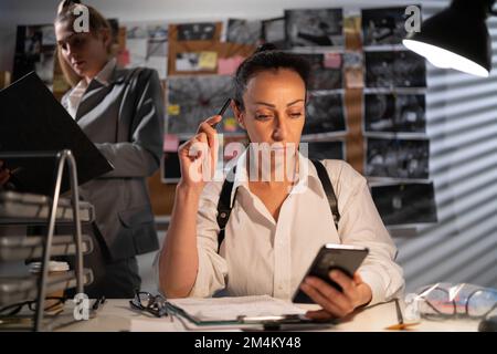 Detektiv arbeitet am Schreibtisch in ihrem Büro, Teamarbeit in der Polizei. Speicherplatz kopieren Stockfoto