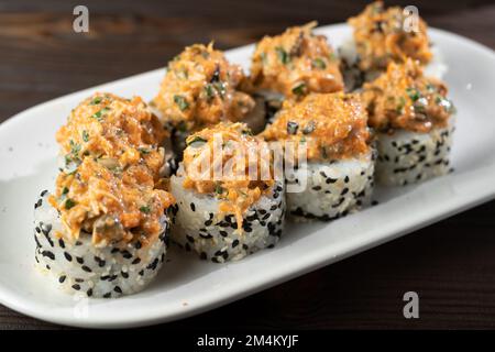 Sushi auf Keramikplatte. Maki-Sushi in minimalistischem Stil. Modernes japanisches Speisenkonzept. Speicherplatz kopieren Stockfoto