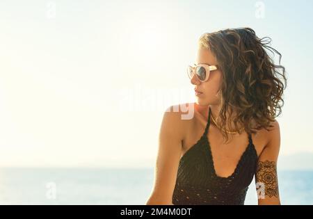 Genießen Sie die Sonne und die Aussicht. Eine wunderschöne junge Frau draußen. Stockfoto