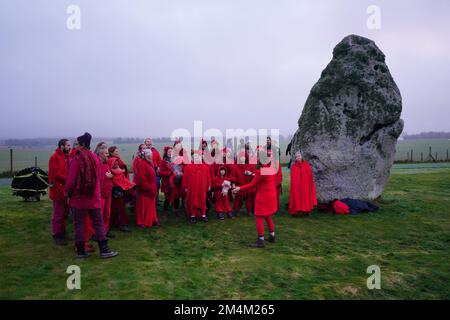 Während des Sonnenaufgangs feiern die Besucher die Wintersonnenwende am Stonehenge prähistorischen Denkmal auf der Salisbury Plain in Wiltshire. Foto: Donnerstag, 22. Dezember 2022. Stockfoto