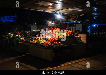 KIEW, UKRAINE - 14. Dezember 2022: Eine Frau verkauft Obst auf einem Markt in Kiew während eines Stromausfalls Stockfoto