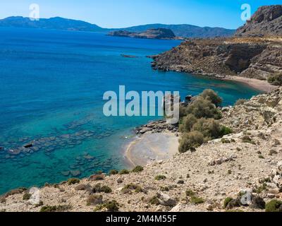 Mittelmeer an der felsigen Küste. Verlassener Strand mit drei Kreuzen und klarem türkisfarbenem Wasser. In der Nähe von Stegna, Archangelos, Rhodos, Griechenland. Stockfoto