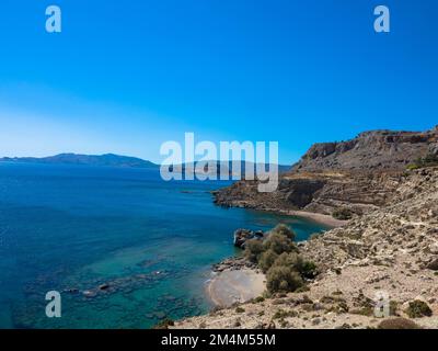 Mittelmeer an der felsigen Küste. Verlassener Strand mit drei Kreuzen und klarem türkisfarbenem Wasser. In der Nähe von Stegna, Archangelos, Rhodos, Griechenland. Stockfoto