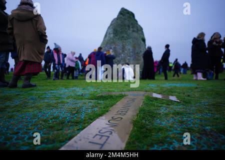 Während des Sonnenaufgangs feiern die Besucher die Wintersonnenwende am Stonehenge prähistorischen Denkmal auf der Salisbury Plain in Wiltshire. Foto: Donnerstag, 22. Dezember 2022. Stockfoto