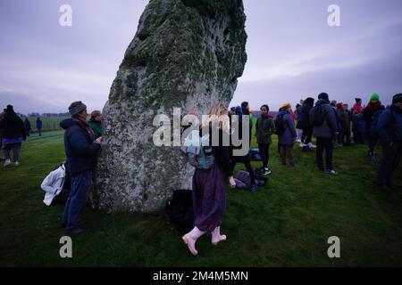 Während des Sonnenaufgangs feiern die Besucher die Wintersonnenwende am Stonehenge prähistorischen Denkmal auf der Salisbury Plain in Wiltshire. Foto: Donnerstag, 22. Dezember 2022. Stockfoto