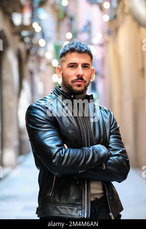 Ein Stadtmensch, der in die Kamera schaut und die Arme kreuzt Stockfoto