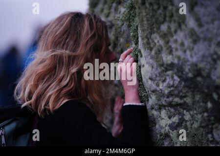 Während des Sonnenaufgangs feiern die Besucher die Wintersonnenwende am Stonehenge prähistorischen Denkmal auf der Salisbury Plain in Wiltshire. Foto: Donnerstag, 22. Dezember 2022. Stockfoto