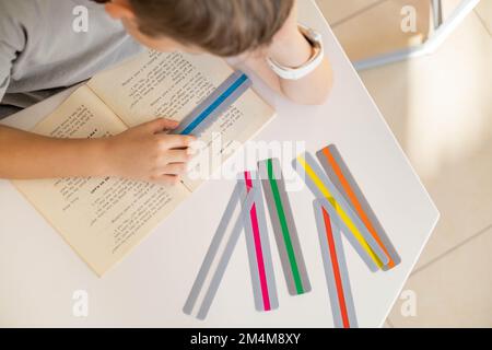 Khabarowsk, Russland, 28. Oktober 2022. Wählen Sie farbige Streifen Lineale Dyslexie Störung Lesen Buch Stockfoto