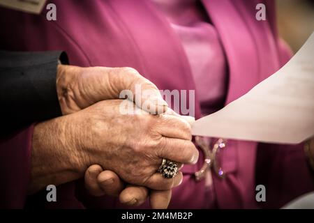 Ältere Paare, bei denen der Ehemann seiner Frau, die an Parkinson leidet, hilft, die Liste der Medikamente zu lesen, die gegen ihre Krankheit eingenommen werden Stockfoto