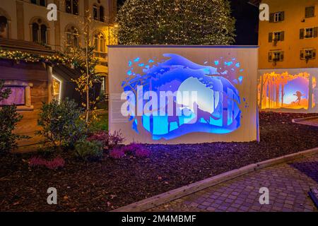 Papierlandschaftsanlagen, dreistufiger Beleuchtungsprozess während der Weihnachtszeit in der Stadt Trento in Trentino Alto Adige, Norditalien. Stockfoto