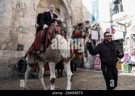 Jerusalem, Israel. 22. Dezember 2022. GEORGE NOLL, Chef der USA Büro für Palästinensische Angelegenheiten, reitet auf einem Kamel am Jaffa-Tor der Altstadt. Kredit: Nir Alon/Alamy Live News Stockfoto