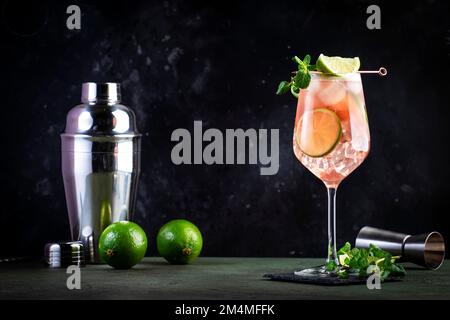 Französischer Orangenmuli, alkoholischer Cocktail mit Wodka, Limettensaft, Ingwerbier, Sirup, roter Orangensaft und Eiswürfel, garniert mit Minze. Dunkle Hintergrundebene Stockfoto