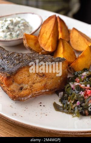 Fischflunder gebraten mit Kartoffeln, Gemüse und Sauce. Gesundes Essen, aus der Nähe Stockfoto