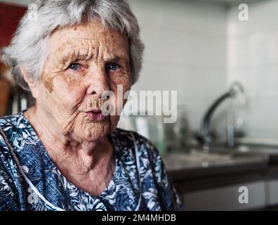 Zweiundneunzig Jahre alte weiße weiße Seniorin zu Hause, die in die Kamera schaut. Stockfoto