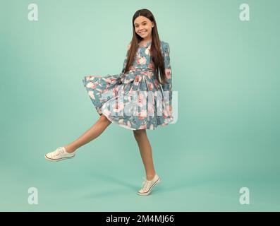 Elegante Teenager Kind Mädchen in Mode Sommerkleid. Mädchen in Baumwollkleid auf blauem Hintergrund isoliert gekleidet. Fröhlicher Teenager, positiv und lächelnd Stockfoto