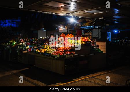 Kiew, Ukraine. 14. Dezember 2022. Eine Frau verkauft Obst auf einem Kiew-Markt während eines Stromausfalls infolge massiver Raketenangriffe auf die Strominfrastruktur der Ukraine durch Russland, mehr als 50 % des Verbrauchs des einheitlichen Energiesystems des Landes gingen verloren, sagte die National Energy Company (NPC) Ukrenergo.Laut dem Übertragungssystemcode, Der Verlust von mehr als 50 % des Verbrauchs bestimmt den Beginn des Systemunfallmodus (Blackout). (Foto: Mykhaylo Palinchak/SOPA Images/Sipa USA) Guthaben: SIPA USA/Alamy Live News Stockfoto