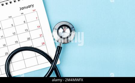 Stethoskop Medizin und Kalender mit leerem Raum auf blauem Hintergrund, Zeitplan, um gesunde Konzepte zu überprüfen. Stockfoto