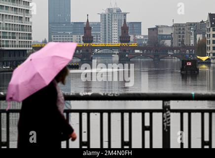 Berlin, Deutschland. 22. Dezember 2022. Die Oberbaumbrücke spiegelt sich im Wasser der Spree bei düsterem, regnerischem Wetter wider. Derzeit sorgen Wolken bei milden Temperaturen für Regen oder Nieselregen. Auch am 24. Dezember ist mit verstreuten Regenschauern und bösen Winden zu rechnen. Kredit: Jens Kalaene/dpa/Alamy Live News Stockfoto