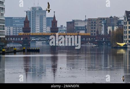 Berlin, Deutschland. 22. Dezember 2022. Die Oberbaumbrücke spiegelt sich im Wasser der Spree bei düsterem, regnerischem Wetter wider. Derzeit sorgen Wolken bei milden Temperaturen für Regen oder Nieselregen. Auch am 24. Dezember sind verstreute Regenschauer und staubige Winde zu erwarten. Kredit: Jens Kalaene/dpa/Alamy Live News Stockfoto