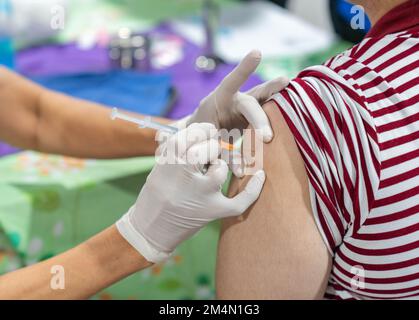 Nahaufnahme einer Frau, die einen Impfstoff in einen schmaleren Arm injiziert bekommt. Gesundheitsfürsorge. Stockfoto