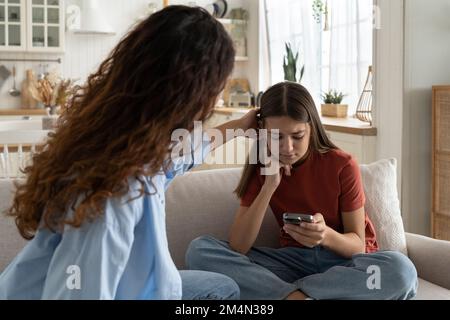 Mutter tröstet traurige Tochter von Freund abgelehnt. Ein aufgebrachtes Teenager, das auf einen Anruf wartet Stockfoto