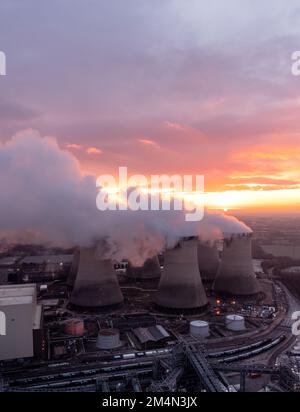 Luftaufnahme von schmutzigen Kohlekraftwerken, die die Atmosphäre bei Sonnenuntergang mit Kohlendioxidemissionen verschmutzen Stockfoto