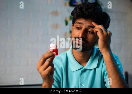 Nahaufnahme, junger Mann bekam Linderung nach Applikation von Balsam oder Salbe auf die Stirn wegen Kopfschmerzen oder Migräne während des Schlafes in der Nacht - Schmerzbegriff Stockfoto